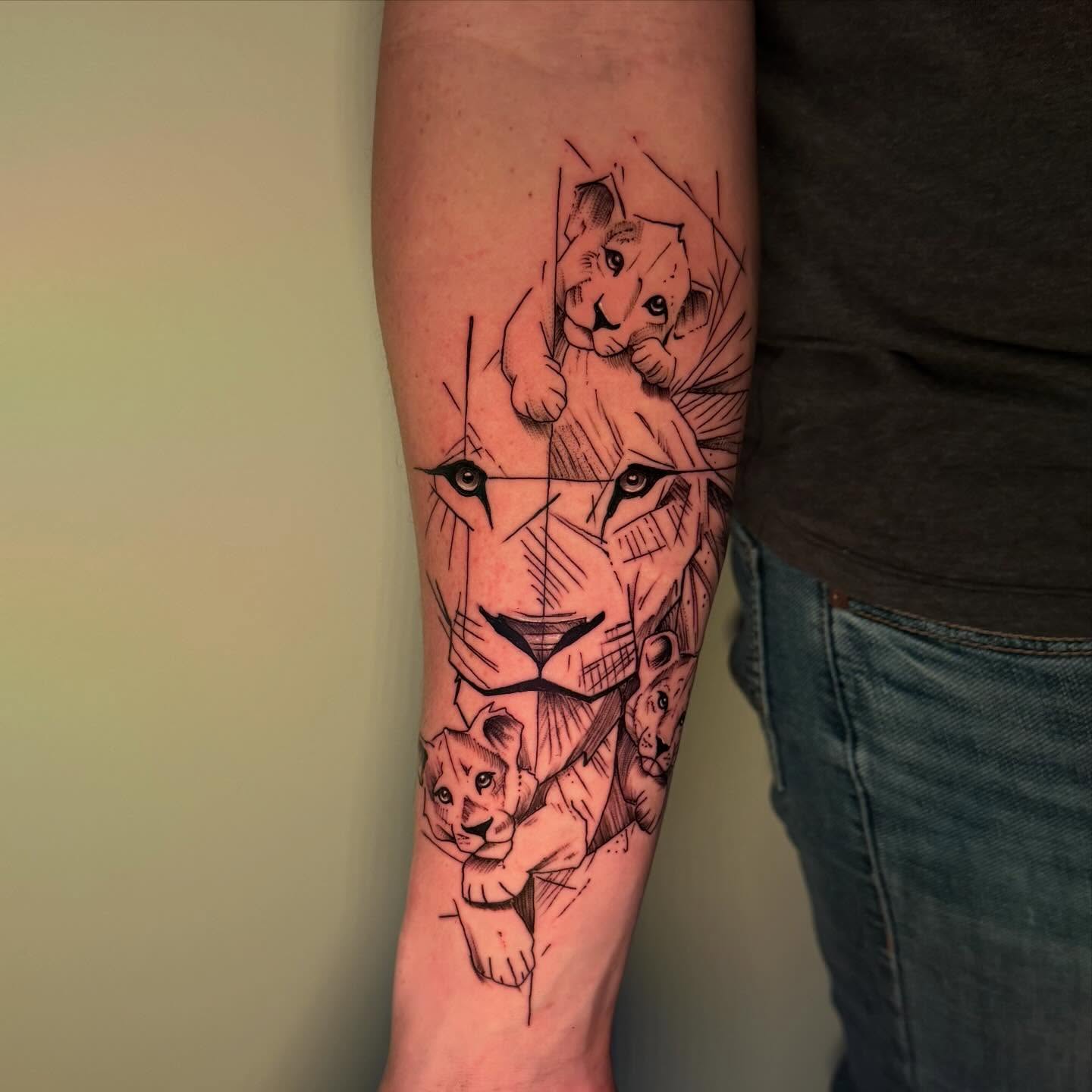 Stunning geometric abstract lion and cub portrait tattoo on forearm